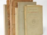 three old books are stacked on top of each other on a white surface