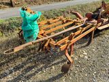 a tractor with a plow attached to it on the side of the road