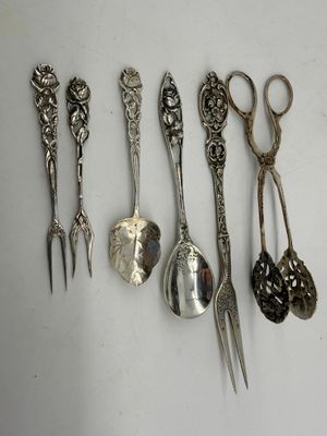 five spoons and a pair of scissors sitting on a table