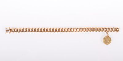 un bracelet en chaîne d'or orné d'une breloque en forme de pièce de monnaie