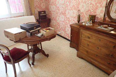 une petite table sur laquelle se trouve une imprimante, dans une pièce