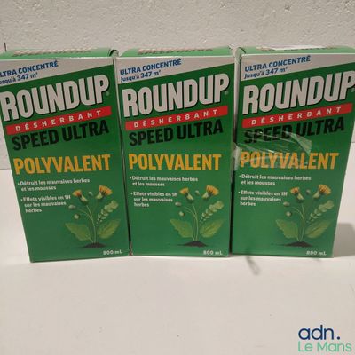 trois boîtes de pesticide Roundup posées sur une table