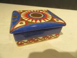 une boîte bleue et rouge ornée d'un motif représentant un soleil