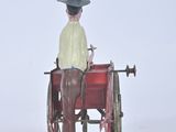 a figurine of a man sitting in a horse drawn carriage