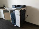 a black and white printer sitting on top of a wooden desk
