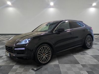 Une Porsche Cayenne noire est garée sur un sol à damier