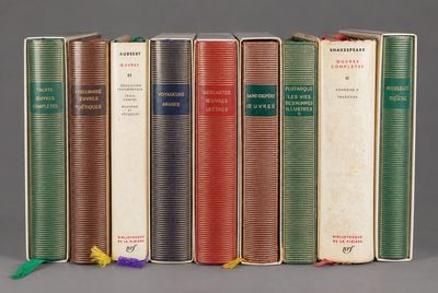 several books are lined up in a row on a gray surface