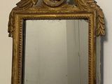 a mirror hanging on the wall with a gold frame