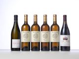 six bottles of wine are lined up on a table