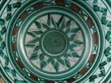 a green and white bowl sitting on top of a table