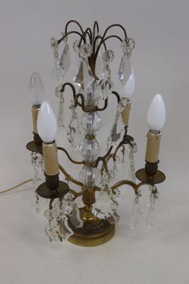 un petit lustre en cristal à trois lumières