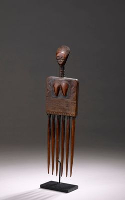 une image représentant un peigne en bois orné d'un visage