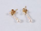 a pair of pearl and gold earrings on a white surface