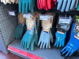 several pairs of gardening gloves are on display in a store