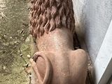 a statue of a lion that is sitting on a bench