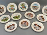neuf assiettes ornées de motifs différents, posées sur une table