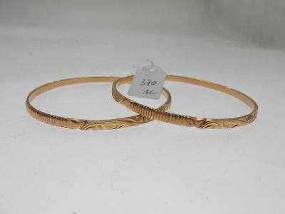deux bracelets en or posés sur une surface blanche, accompagnés d'une étiquette de prix