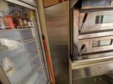 un four argenté dont la porte est ouverte, à côté d'un réfrigérateur