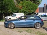 a blue car parked in a parking lot next to other cars