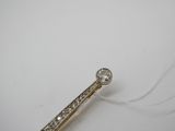 une photo d'une broche en forme de lingot de diamant posée sur une surface blanche
