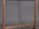 une image représentant un portant à vêtements en bois sur fond gris