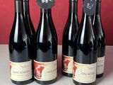 trois bouteilles de vin rouge sont alignées sur un comptoir