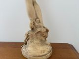 a statue of a woman standing on top of a wooden table