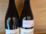 two bottles of wine sitting on a table next to each other