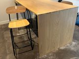 two stools sitting at a table with a computer on it