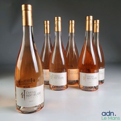six bottles of wine are lined up in a row on a table