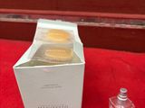 des flacons de parfum posés sur un support rouge, à côté d'un coffret de parfum