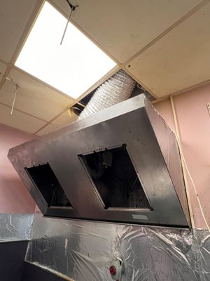 une photo d'une cuisine avec une cuisinière au milieu de la pièce