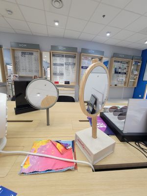 un bureau sur lequel se trouvent un miroir, un ordinateur portable et d'autres objets