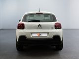 the rear end of a white citrole parked in a room