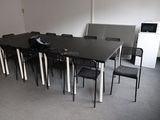 a black table and chairs in a room with a refrigerator