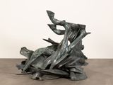 une sculpture représentant un oiseau perché sur un tas de feuilles