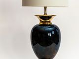 une lampe noire et dorée avec un abat-jour blanc