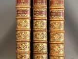trois vieux livres sont empilés sur une table