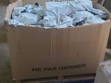 une boîte en carton remplie de matière plastique bleue, posée sur une palette