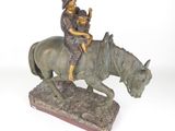 statue en bronze représentant un homme à cheval avec un enfant sur le dos