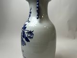 a blue and white vase sitting on a white surface