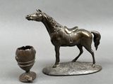 a bronze statue of a horse and an egg shell