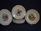 quatre assiettes ornées de photos d'enfants, posées sur une table