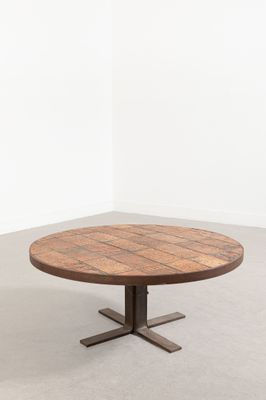une table ronde en bois avec des pieds en métal et un plateau en bois