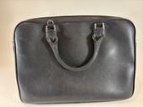 black leather handbag sitting on a white surface with a white background