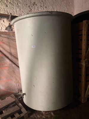 a white trash can sitting in the corner of a room
