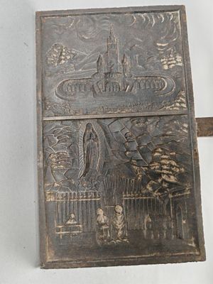 un briquet en métal sur lequel est représenté un château
