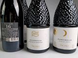 trois bouteilles de vin posées l'une à côté de l'autre sur une table