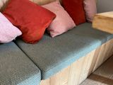 a wooden bench with a bunch of pillows on top of it