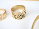 two gold rings sitting on a table next to each other